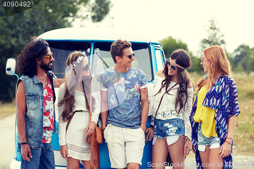 Image of smiling young hippie friends over minivan car