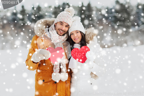 Image of happy couple with red hearts over winter landscape