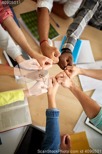 Image of group of international students making fist bump