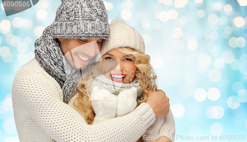 Image of happy family couple in winter clothes hugging