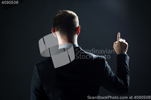 Image of businessman pointing finger to something invisible