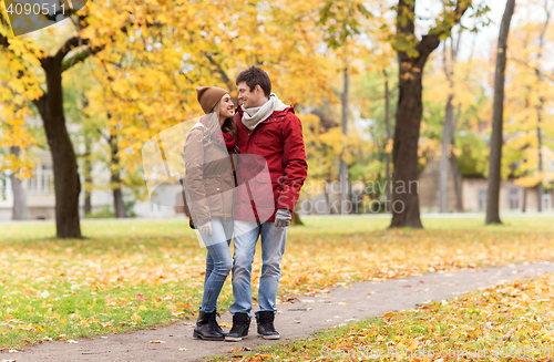 Image of happy young couple walking in autumn park