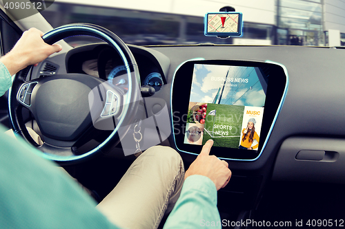 Image of close up of man driving car with news application