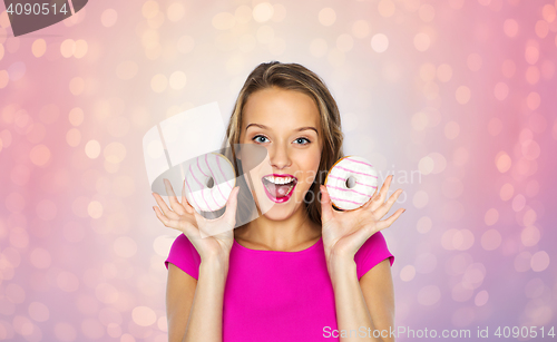 Image of happy woman or teen girl with donuts