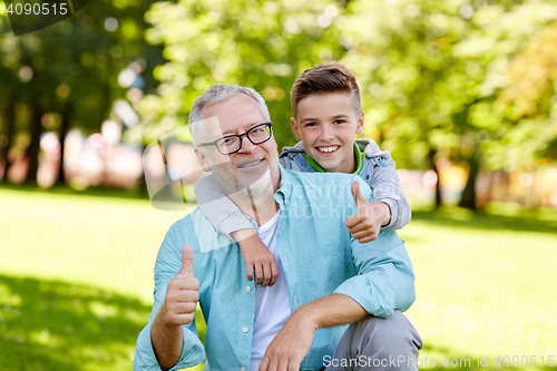 Image of grandfather and boy showing thumbs up at summer