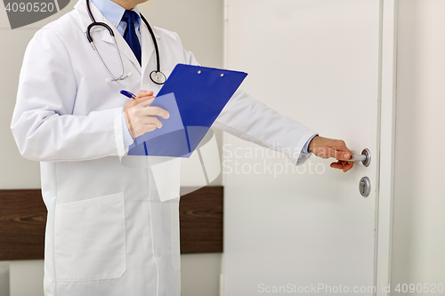 Image of close up of doctor with clipboard at hospital door