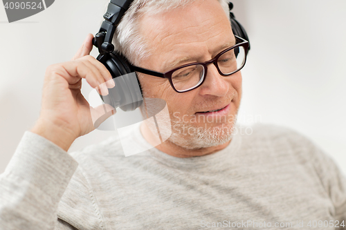 Image of happy man in headphones listening to music at home