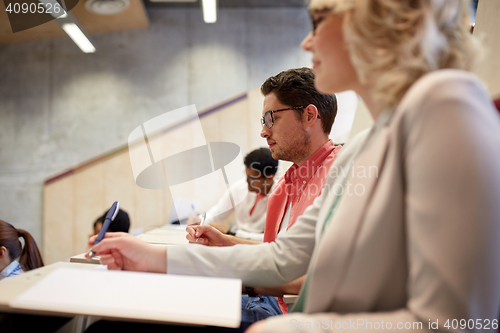 Image of group of students with notebooks in lecture hall