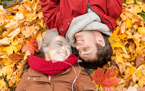 Image of close up of smiling couple lying in autumn park