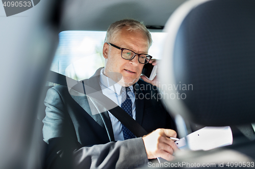 Image of senior businessman calling on smartphone in car