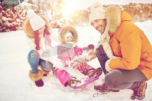 Image of happy family with kid on sled having fun outdoors