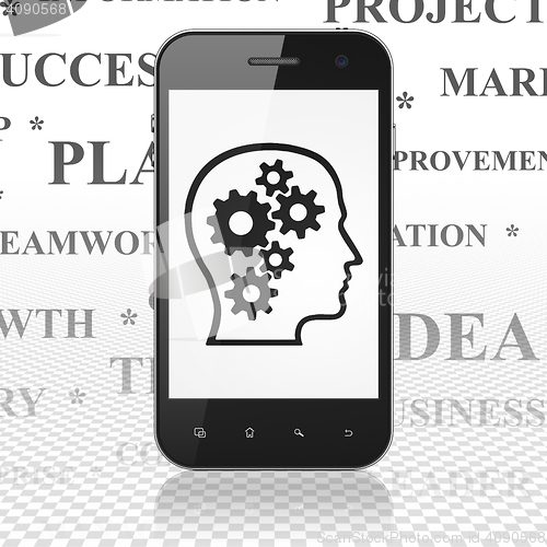 Image of Finance concept: Smartphone with Head With Gears on display