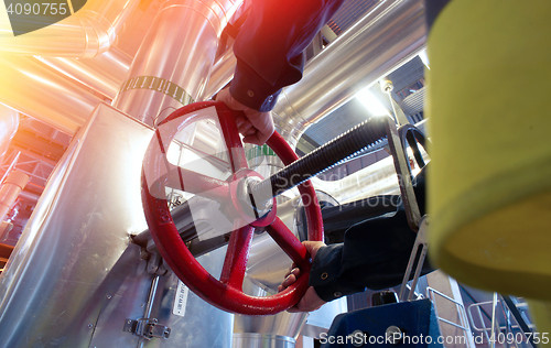 Image of factory worker turning valve