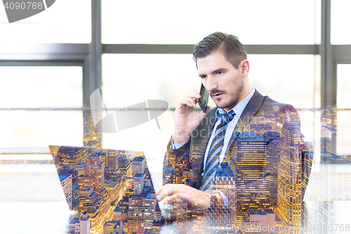 Image of Businessman in office working on laptop computer.