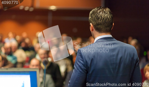 Image of Public speaker giving talk at Business Event.