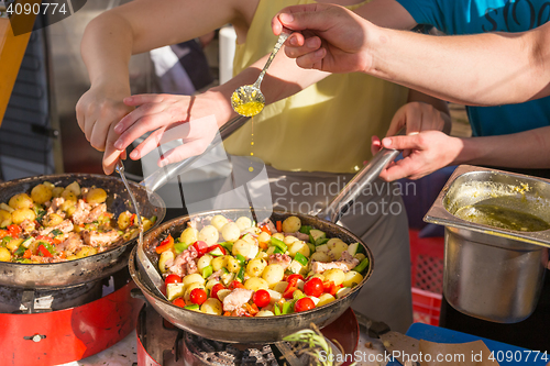 Image of Cheff cooking traditional Mediterranean octopus on street stall.