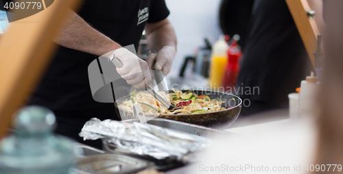 Image of Cheff cooking on outdoor street food festival.