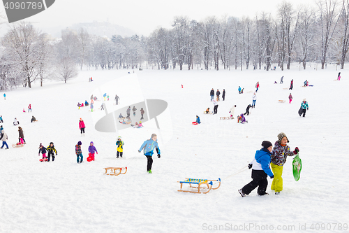 Image of Winter fun, snow, family sledding at winter time.