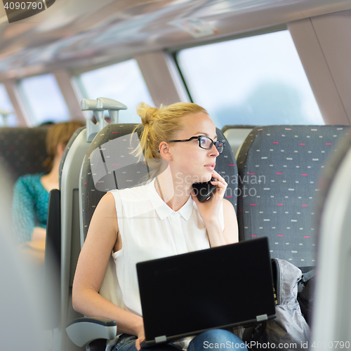 Image of Business woman working while travelling by train.