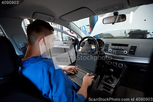 Image of mechanic man with laptop making car diagnostic