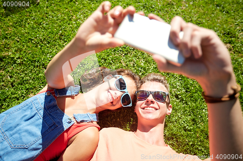 Image of happy couple taking selfie on smartphone at summer