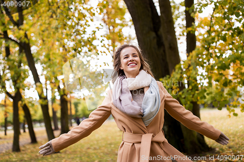 Image of beautiful happy young woman walking in autumn park