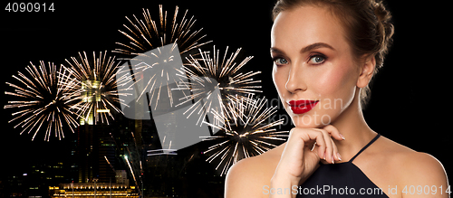 Image of beautiful woman in black over firework lights