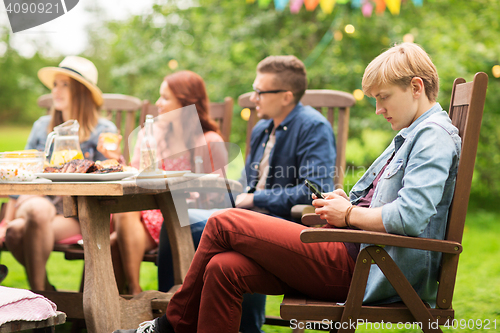 Image of man with smartphone and friends at summer party