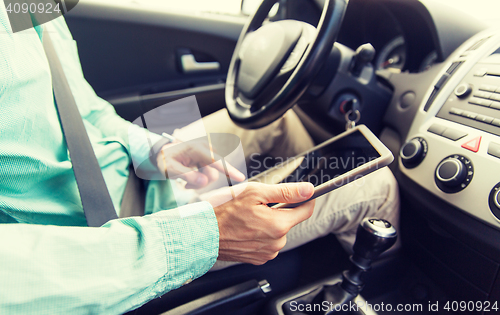 Image of close up of young man with tablet pc driving car