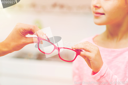 Image of close up of girl taking glasses at optics store