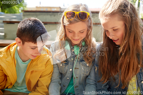 Image of three happy teenage friends headphones