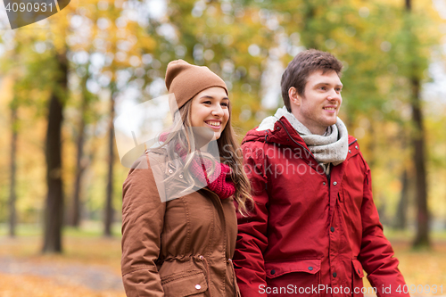 Image of happy young couple walking in autumn park