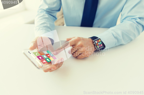 Image of close up of hands with smart phone and watch