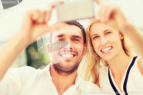 Image of happy couple taking selfie with smartphone 