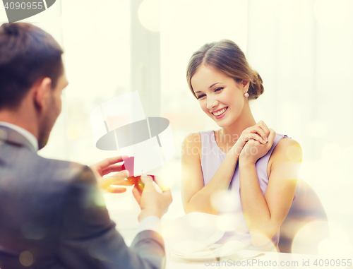 Image of excited young woman looking at boyfriend with ring