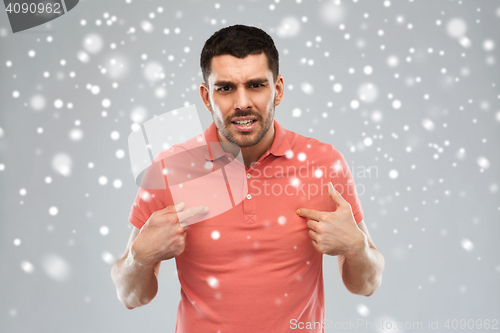 Image of angry man pointing finger to himself over snow