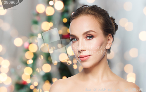 Image of beautiful woman face over christmas lights