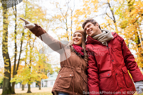Image of happy young couple walking in autumn park