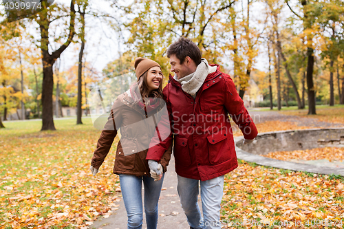 Image of happy young couple walking in autumn park