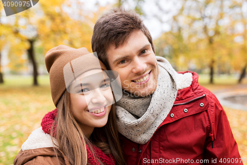 Image of happy young couple walking in autumn park