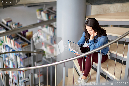 Image of high school student girl reading book at library