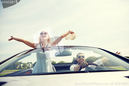 Image of happy man and woman driving in cabriolet car