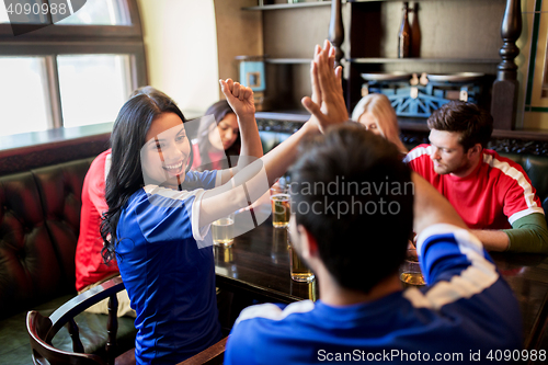 Image of football fans with beer celebrating victory at bar