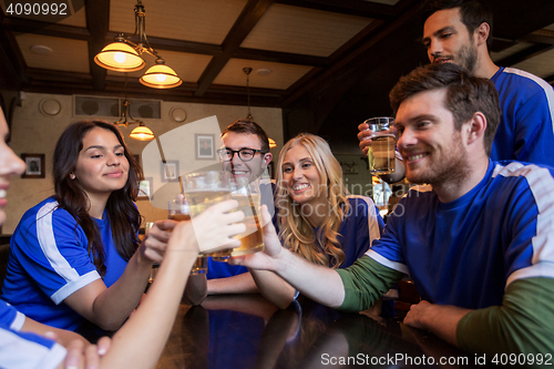 Image of football fans clinking beer glasses at sport bar