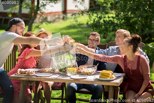 Image of happy friends having dinner at summer garden party