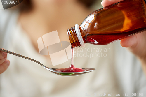 Image of woman pouring medication from bottle to spoon