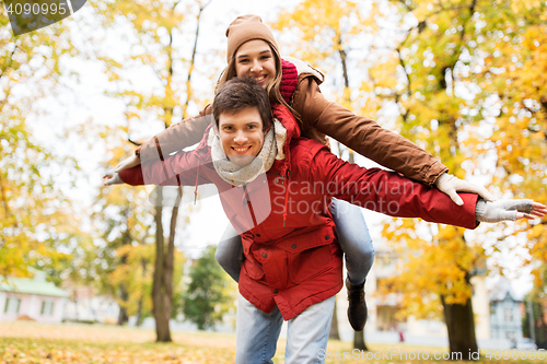 Image of happy young couple having fun in autumn park