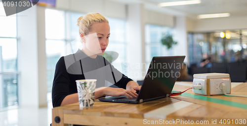 Image of Female freelancer remotely working on the go.