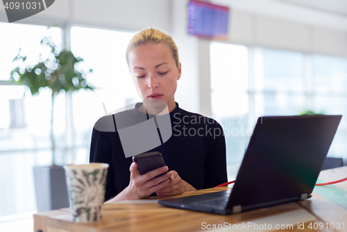 Image of Female freelancer remotely working on the go.