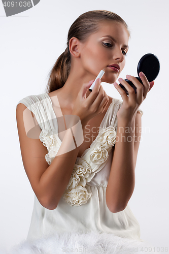 Image of Young Woman Applying Cosmetics